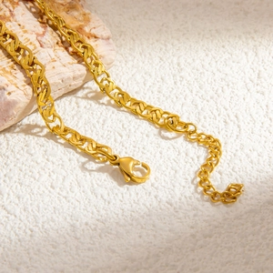 Macro detail of 18k gold plated hollow Cuban chain with lobster clasp on natural stone