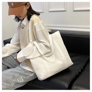 Minimalist white corduroy tote bag showing large capacity and wide shoulder strap