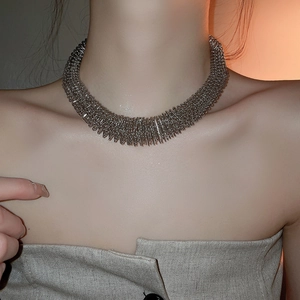 Close-up of heavy industrial silver spring coil necklace on model neck and collarbone