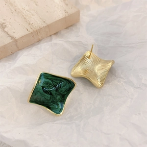 Detailed view of geometric square gold-plated earrings with green enamel marble texture