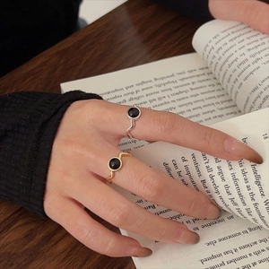 Close-up of 925 silver and gold wave rings with black onyx on an open book