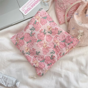 Detailed close-up of pink bunny floral drawstring storage bags with textured fabric