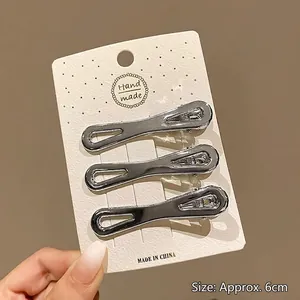 Détail de trois barrettes Y2K en métal argenté sur une carte mesurant environ 6 cm