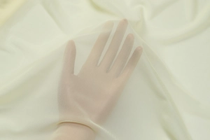 Detail view of the beige sheer mesh fabric showing fine texture and transparency