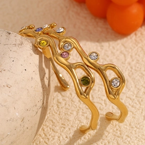 Elegant 18K gold plated branch bracelet with colorful rhinestones on a textured stone