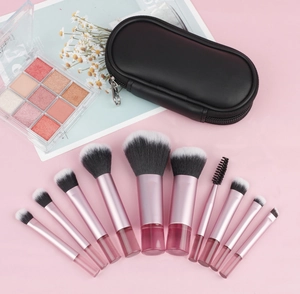 Close-up of 10 pink gradient makeup brushes with black storage case and soft fiber bristles