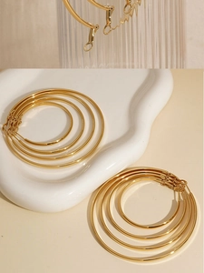 Golden stainless steel hoop earrings in various sizes displayed on a ceramic tray