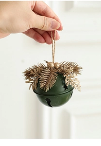 Close-up of green Christmas bell pendant with gold pine needles held in hand