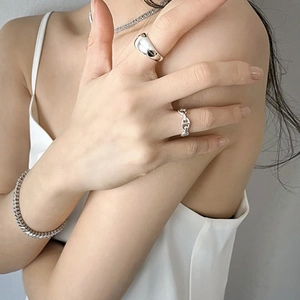 Close-up of minimalist 925 sterling silver rings and jewelry on a model's hand