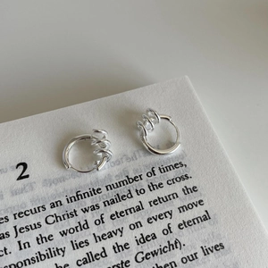 925 sterling silver hoop earrings with triple rotating rings on a vintage book