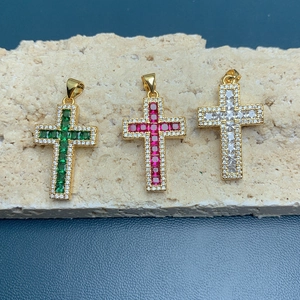 Detailed macro view of 18k gold cross pendants with colorful zircon center stones