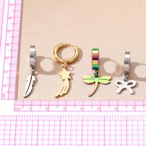 Polished metal earrings with feather, star, dragonfly and bow charms on a scale