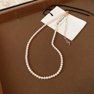 Close-up of pearl necklace featuring gold-plated lobster clasp and adjustable link chain
