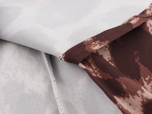 Close-up of leopard print fabric texture showing stitching and brown pattern details