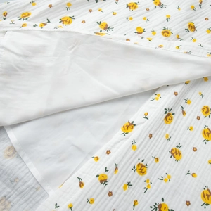 Détail de la robe à imprimé floral jaune avec texture de coton plissée