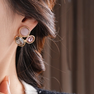 Close-up of vintage oval cat-eye stone earrings in gold setting worn by model