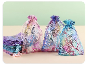 Close-up of organza gift bags with gold coral patterns and satin drawstring closures