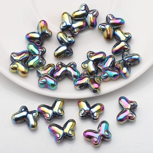 Macro view of colorful butterfly-shaped glass beads with iridescent metallic luster for DIY