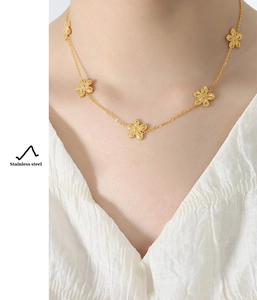 Detail of gold daisy flower necklace on model, featuring durable stainless steel material