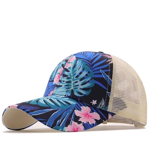 Detail of tropical floral print trucker hat with breathable beige mesh and curved brim