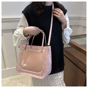 Détail du sac cabas en peluche rose avec broderie papillon et texture douce