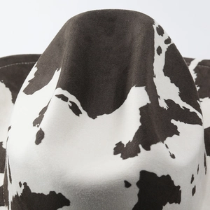 Gros plan d'un chapeau de cowboy western avec motif vache noir et blanc en feutre doux