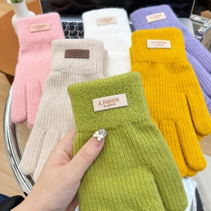 Detail of candy-colored knitted gloves with ribbed texture and woven fashion wrist labels