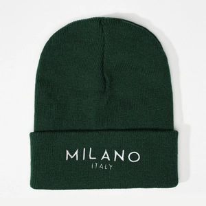 Close-up of white MILANO ITALY embroidery on a dark green knitted beanie hat