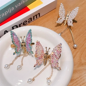 Detail view of butterfly hair clips with sparkling sequins and elegant pearl tassels