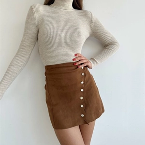 Detail of a brown faux suede A-line skirt featuring silver buttons and wavy hem design