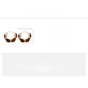 Detail view of retro C-shaped amber resin earrings with dimensions 2x2.5cm and 10.9g weight
