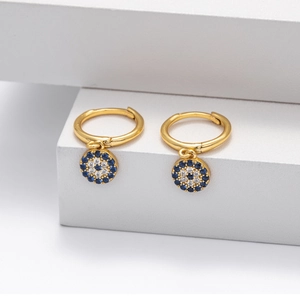 Macro detail of gold Evil Eye earrings with blue and white zircon pavé setting