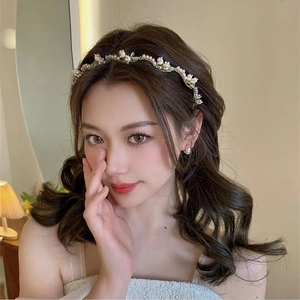 Detailed close-up of handmade pearl flower headband and earring set on a female model