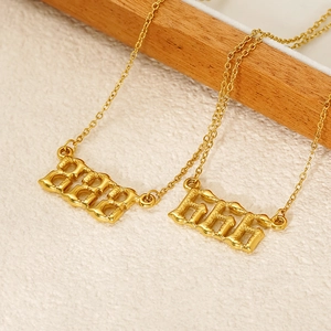 Detail of 222 and 555 bubble number pendants in 18k gold plated stainless steel