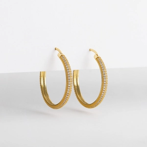 Detailed close-up of 18K gold hoop earrings with micro-set shimmering cubic zirconia stones