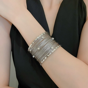 Detail of silver multi-layer cuff bracelet with sparkling crystals on a woman's wrist