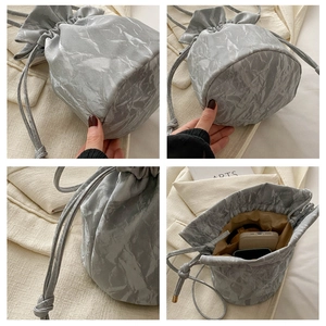 Four-angle detail shots of silver bucket bag with marble texture and drawstring closure