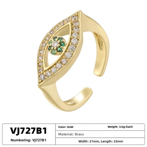 Macro view of adjustable gold brass evil eye ring featuring green and white crystals