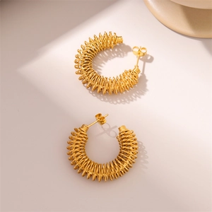 Macro detail of 18K gold plated stainless steel twisted spiral C-shaped hoop earrings
