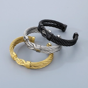 Detailed view of cable-textured open bangles in gold, silver, and black stainless steel