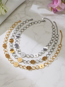 Detailed macro view of gold and silver layered necklaces with zircon cross charms on marble