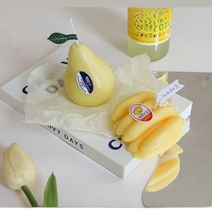 Detailed view of handmade pear and banana shaped candles as creative home decor