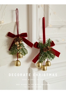 Detail of red velvet bow Christmas hanging ornaments with pine cones and golden bells