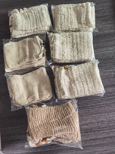 Detailed view of seven natural jute soap bags with wooden beads in clear packaging