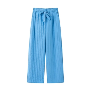Detail of blue quilted wide-leg trousers with elastic drawstring waist and vertical seams