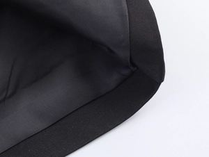 Macro detail of high-quality stitching and fabric texture on a long black street coat