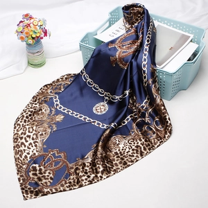 Detail of navy blue satin silk square scarf with leopard border and gold chain pattern
