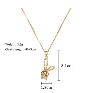 Detail view of golden bunny pendant necklace with clear crystals and red gemstone eyes