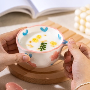 Handmade wavy ceramic mug with pink floral and blue heart patterns including a matching spoon