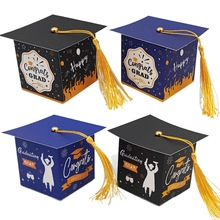 Detail view of mini graduation cap gift boxes with golden tassels and congratulatory prints